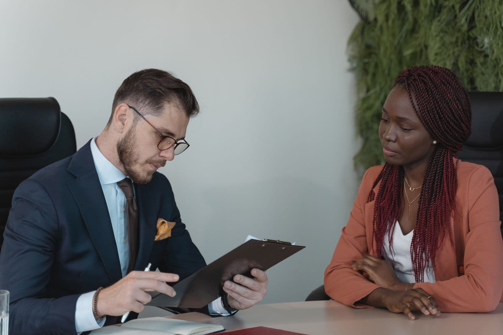 An interviewer reviewing a candidate profile across a table in a modern office